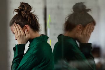mujer tapándose la cara con las manos